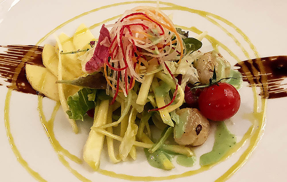 Salat von grüner Flugmango mit Scallops, Schalotten, Dill, Ruccola und gerösteten Erdnüssen. Foto: Uta Petersen