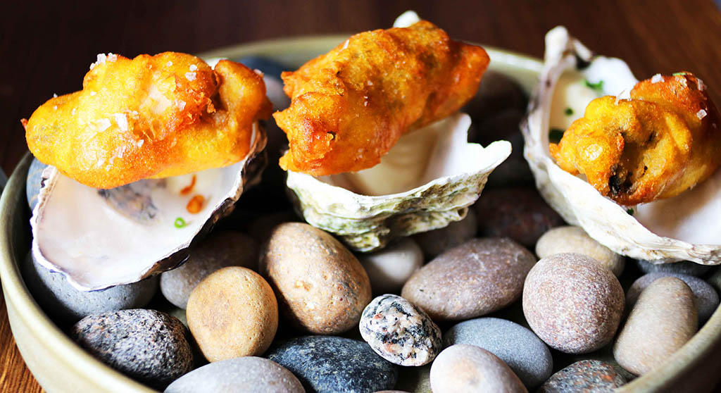Nicht nur für Gourmets: auf Steinen und in Austernschalen servierte gebackene knusprige Austern aus Donegal mit Zitronen-Aioli. Foto: Ellen Spielmann
