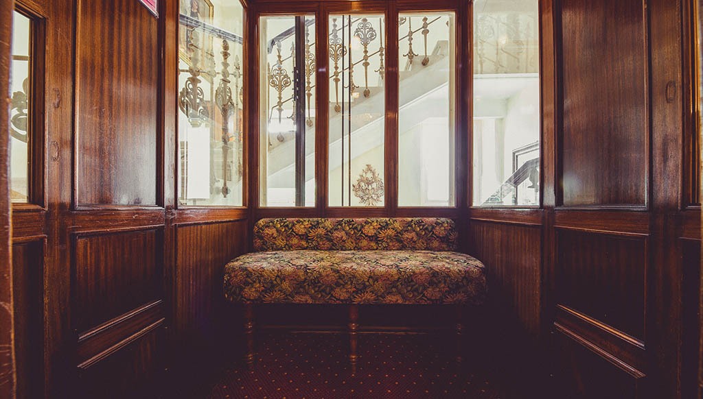 Unter Berücksichtigung sämtlicher Denkmalschutzauflagen ließen Sissi und Florian den eleganten, hölzernen Sofa-Kabinenaufzug von 1914 im Hotel ADRIA aufwändig Instand setzen. Foto: Armin Terzer