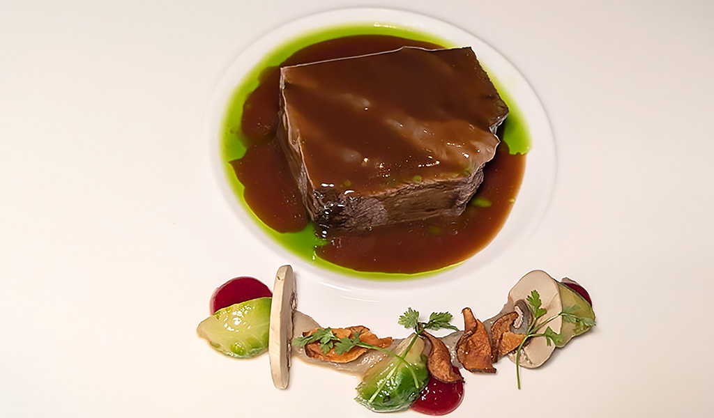 Ochsenbacke mit Melissenöl, samtigem Topinamburpüree, Champignons, Preiselbeeren und Rosenkohl. Foto: Carola Faber