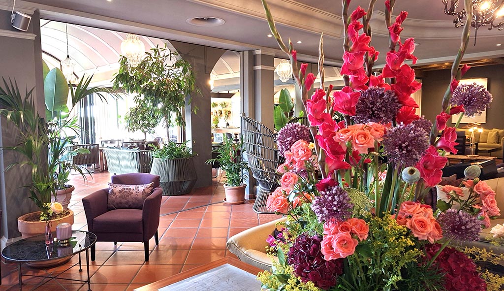 Ein Farbspektakel, das sofort fesselt: Üppige Blumen empfangen den Gast und erzählen Geschichten – die Lobby wird zum ersten Erlebnis. Foto: Birgit Werner