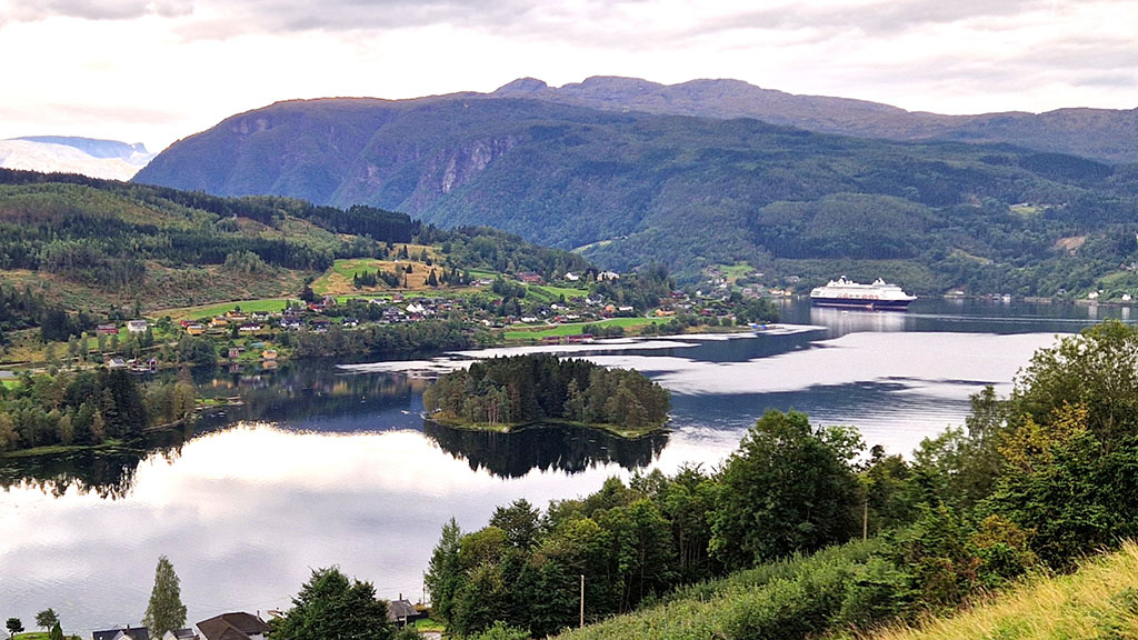 Umgeben von steilen Bergen und weitläufigen Obstgärten bietet der Fjordpanorama-Blick einen perfekten Eindruck von Norwegens natürlicher Schönheit. Foto Andreas Bienert