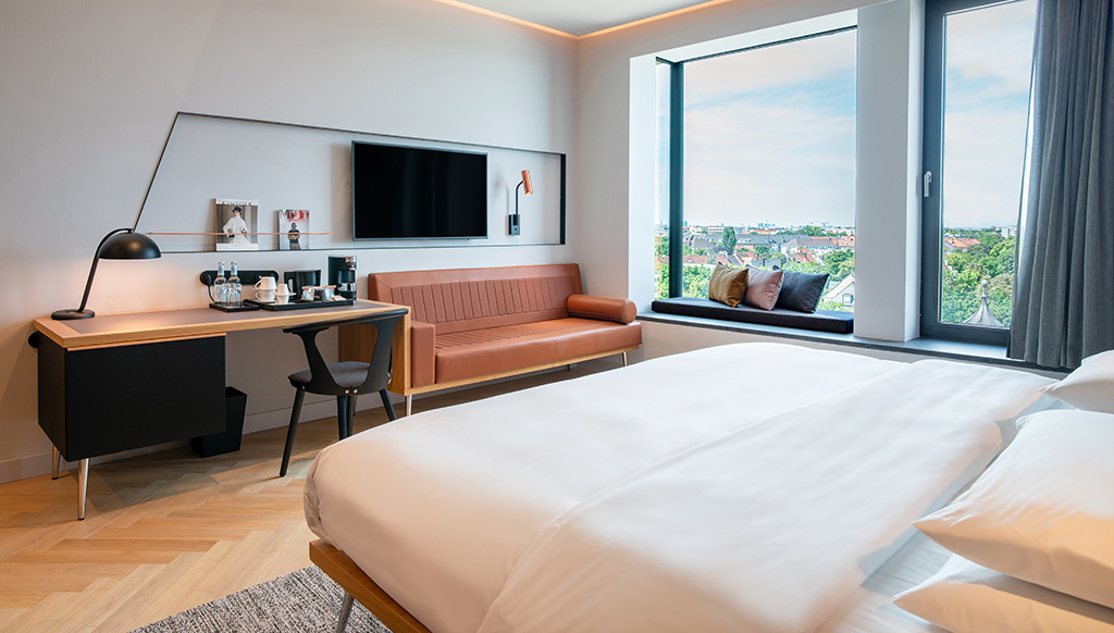 Die Zimmer und Suiten sind durch hochwertige Materialien wie warmes Holz und Stoffe wohnlich gestaltet. Foto: Andaz Munich Schwabinger Tor