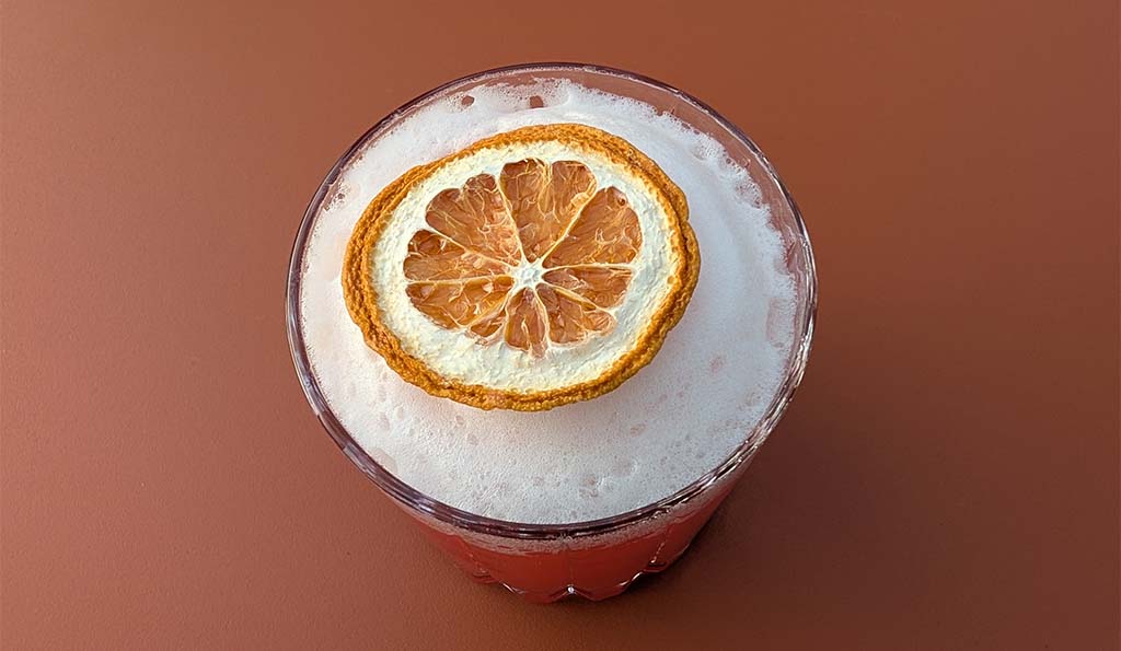 Im Mittelpunkt steht, was ins Glas kommt: Cocktail aus Gin und Blutorange. Foto: Carola Faber