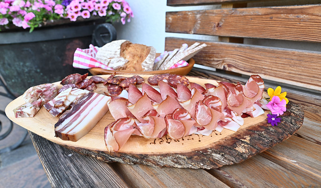 Kaminwurzen, Schinken und Speck aus eigener Hofverarbeitung liegen zur Verkostung bereit. Foto: Alpbachtal Tourismus / Gabriele Grießenböck